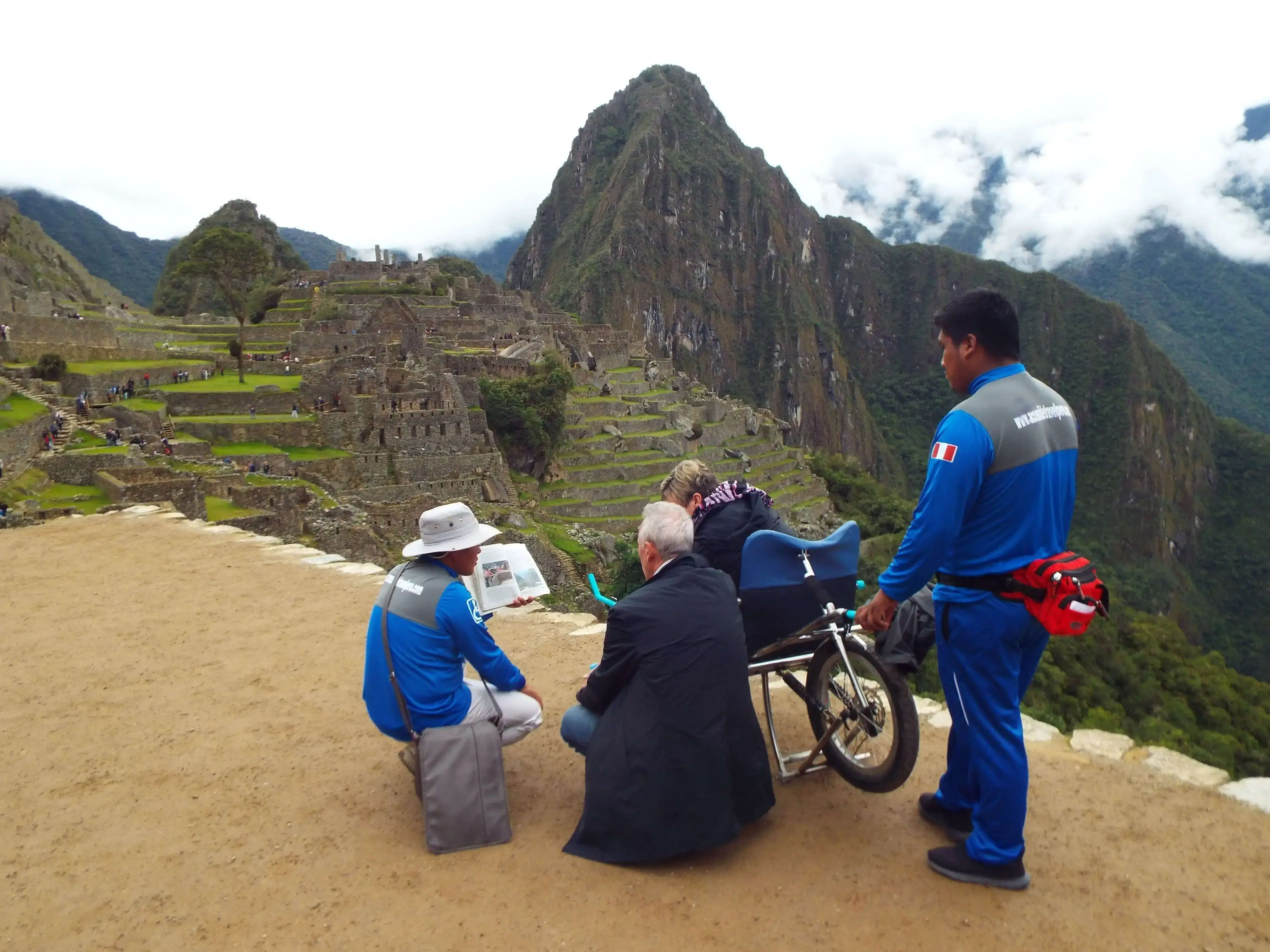 Accessible Travel Peru guides assisting wheelchair client Machu Picchu Peru panoramic viewpoint